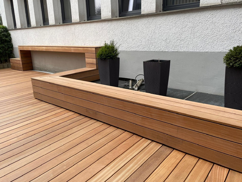 Moderne Holzterrasse mit eingebauten Sitzbänken am Haus, realisiert von der Zimmerei Friebel aus Hüllhorst